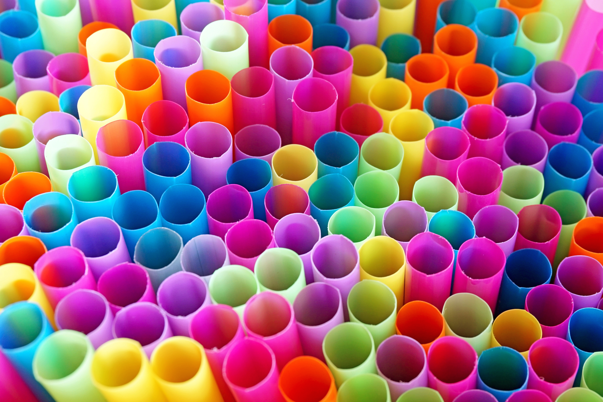 A bundle of colorful, paralell drinking straws.